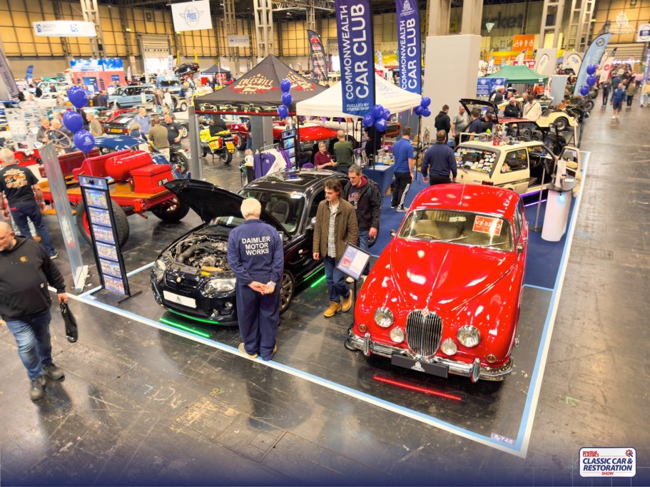 Classic car show featuring various models, with attendees exploring the exhibits.