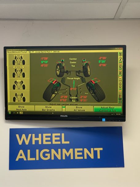 Screen displaying wheel alignment information with graphical representation of vehicle wheels.