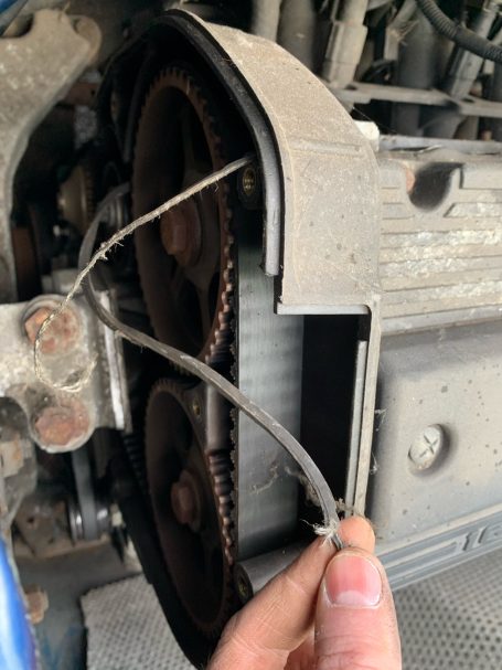 Close-up of a mechanical part with two pulleys and a wire connector.